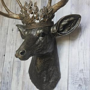 faux taxidermy deer head wall mount in black with gold accenting and gold antler. A gold metal work crown rests atop the deers head.