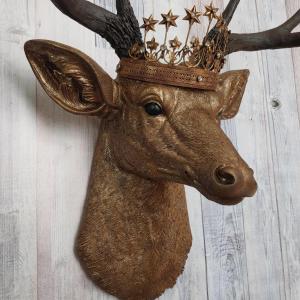 Faux taxidermy deer head that's been painted antique gold with chestnut brown accenting. The antlers are chestnut brown and a vintage inspired Santos star crown/tiara sits arop the deers head.