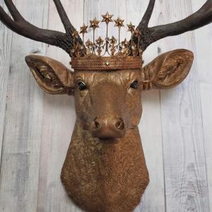 Faux taxidermy deer head that's been painted antique gold with chestnut brown accenting. The antlers are chestnut brown and a vintage inspired Santos star crown/tiara sits arop the deers head.