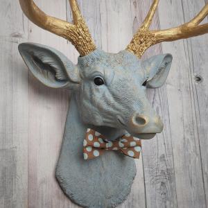 Faux taxidermy deer head painted winter blue with gold antlers and a removable brown and blue polka dot bow tie