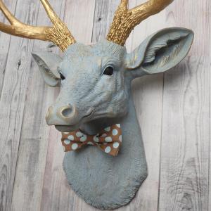 Faux taxidermy deer head painted winter blue with gold antlers and a removable brown and blue polka dot bow tie