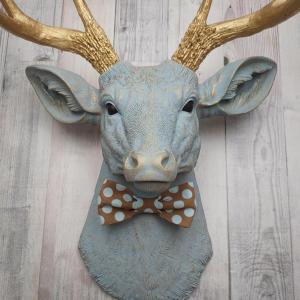 Faux taxidermy deer head painted winter blue with gold antlers and a removable brown and blue polka dot bow tie