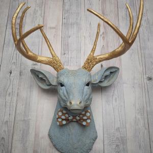 Faux taxidermy deer head painted winter blue with gold antlers and a removable brown and blue polka dot bow tie