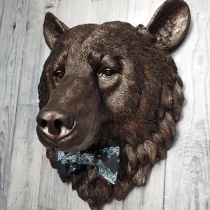 Faux taxidermy bear head painted dark copper with black accenting with mulit dark blue and white fabric bow tie.