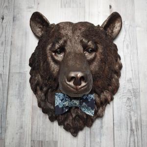 Faux taxidermy bear head painted dark copper with black accenting with mulit dark blue and white fabric bow tie.