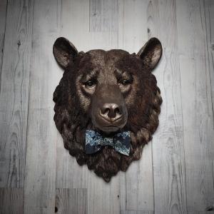 Faux taxidermy bear head painted dark copper with black accenting with mulit dark blue and white fabric bow tie.