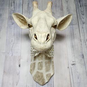 faux taxidermy giraffe head wall mount with a bow tie around it's neck.