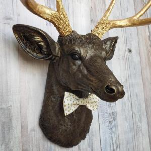Faux taxidermy rubbed bronze deer head with gold antlers and white and gold polka dot bow tie
