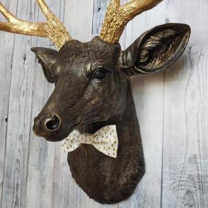 Faux taxidermy rubbed bronze deer head with gold antlers and white and gold polka dot bow tie