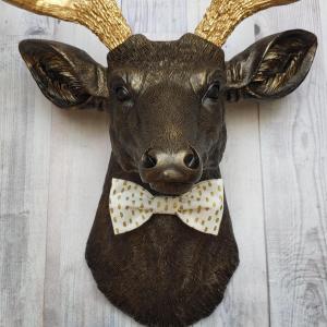 Faux taxidermy rubbed bronze deer head with gold antlers and white and gold polka dot bow tie