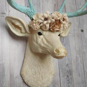 Faux taxidermy deer head, painted antique white with spa blue and gold accents. Antlers are spa blue with gold accents. A removable floral crown made out of cream sola flowers rests atop the deer head