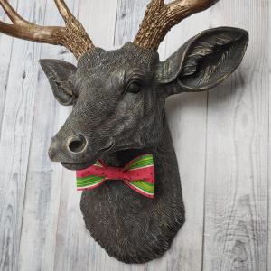 Faux taxidermy deer head painted chestnut brown and accented with antique white and antique gold. The antlers have been painted antique gold and the eyes have been painted black.Watermelon print fabric bow tie accents the deers neck.