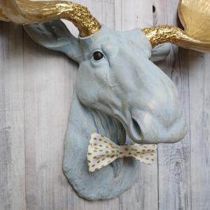Faux taxidermy moose head painted winter blue with gold antlers with a white and gold polka dot bow tie.