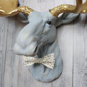 Faux taxidermy moose head painted winter blue with gold antlers with a white and gold polka dot bow tie.