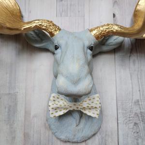 Faux taxidermy moose head painted winter blue with gold antlers with a white and gold polka dot bow tie.