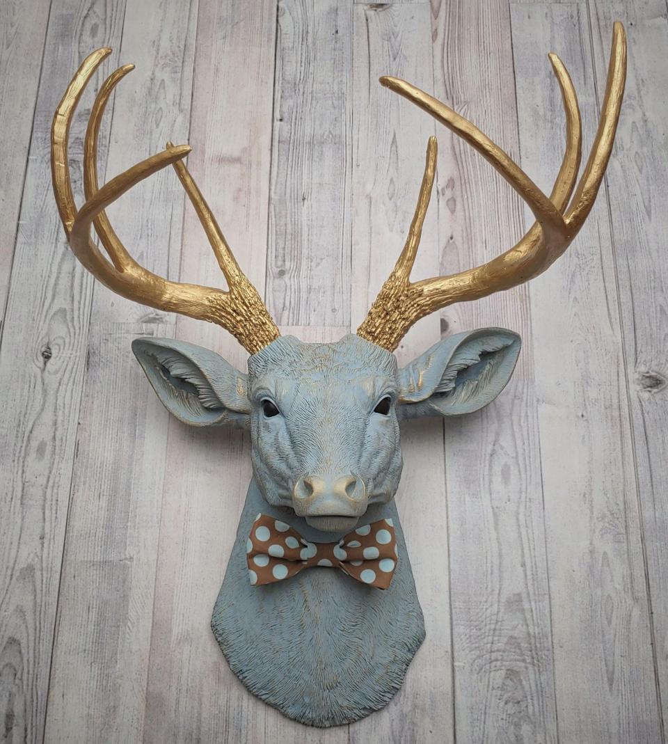 Faux taxidermy deer head painted winter blue with gold antlers and a removable brown and blue polka dot bow tie
