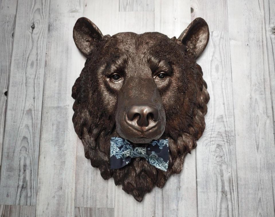 Faux taxidermy bear head painted dark copper with black accenting with mulit dark blue and white fabric bow tie.