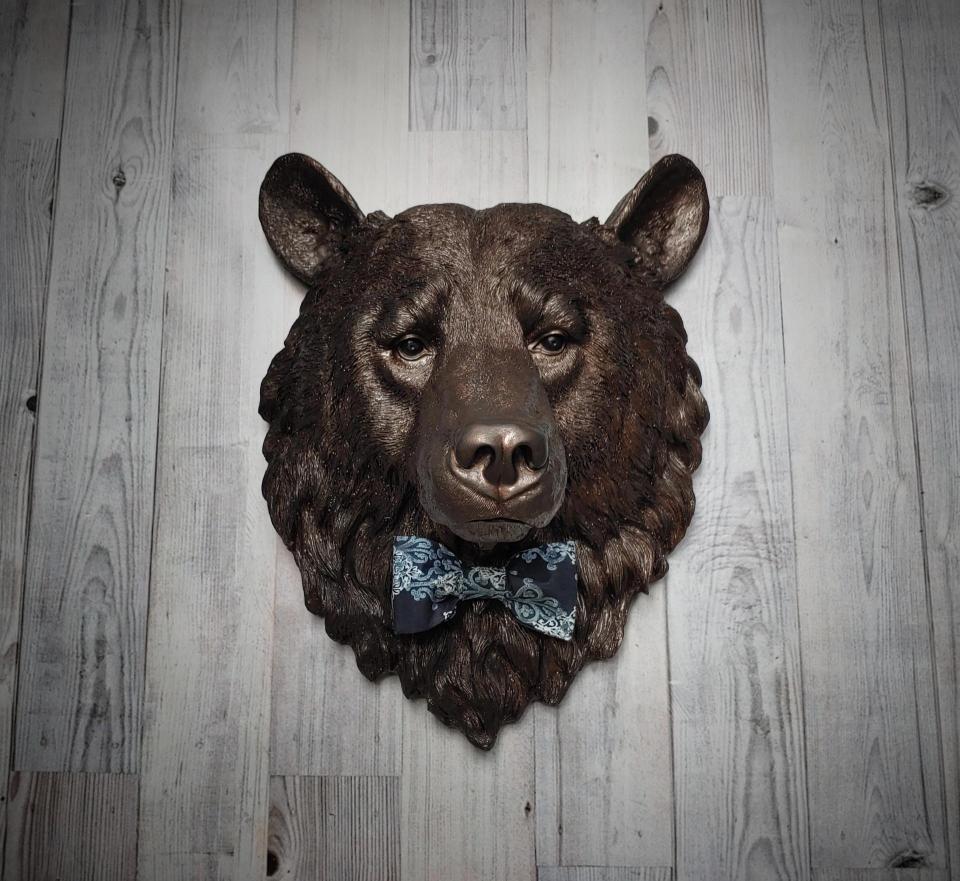 Faux taxidermy bear head painted dark copper with black accenting with mulit dark blue and white fabric bow tie.