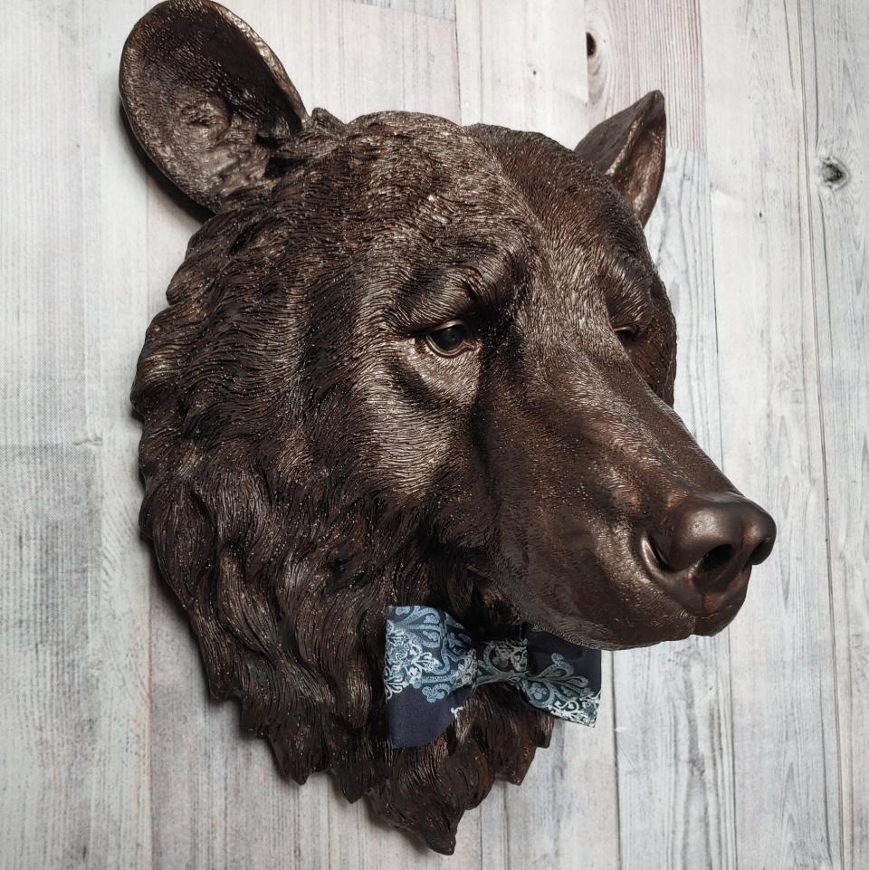 Faux taxidermy bear head painted dark copper with black accenting with mulit dark blue and white fabric bow tie.