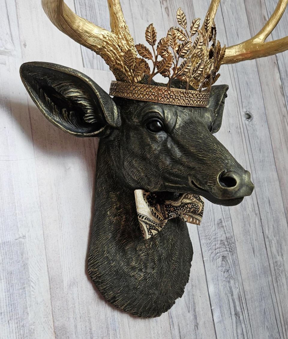 Faux taxidermy deer head with gold metal leaf crown and bow tie.