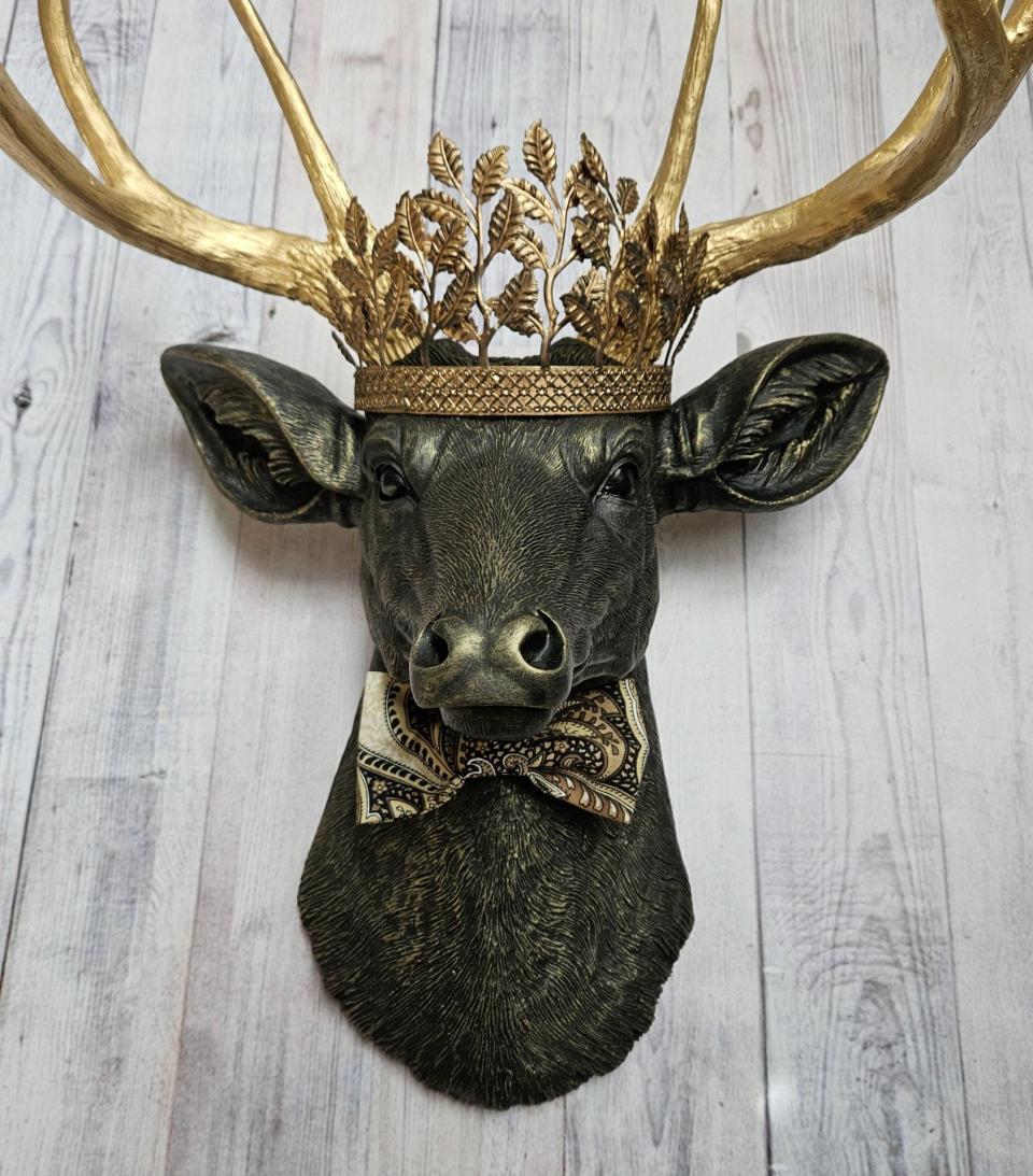 Faux taxidermy deer head with gold metal leaf crown and bow tie.