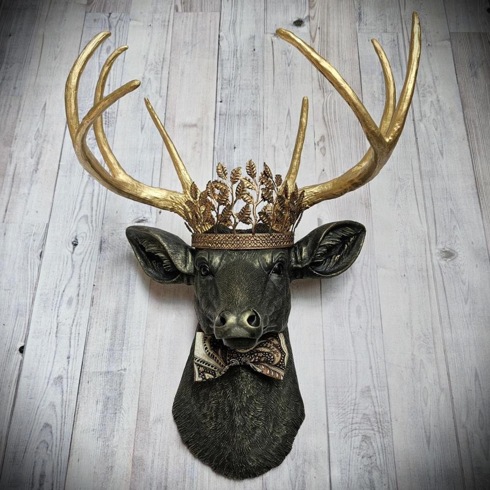 Faux taxidermy deer head with gold metal leaf crown and bow tie.