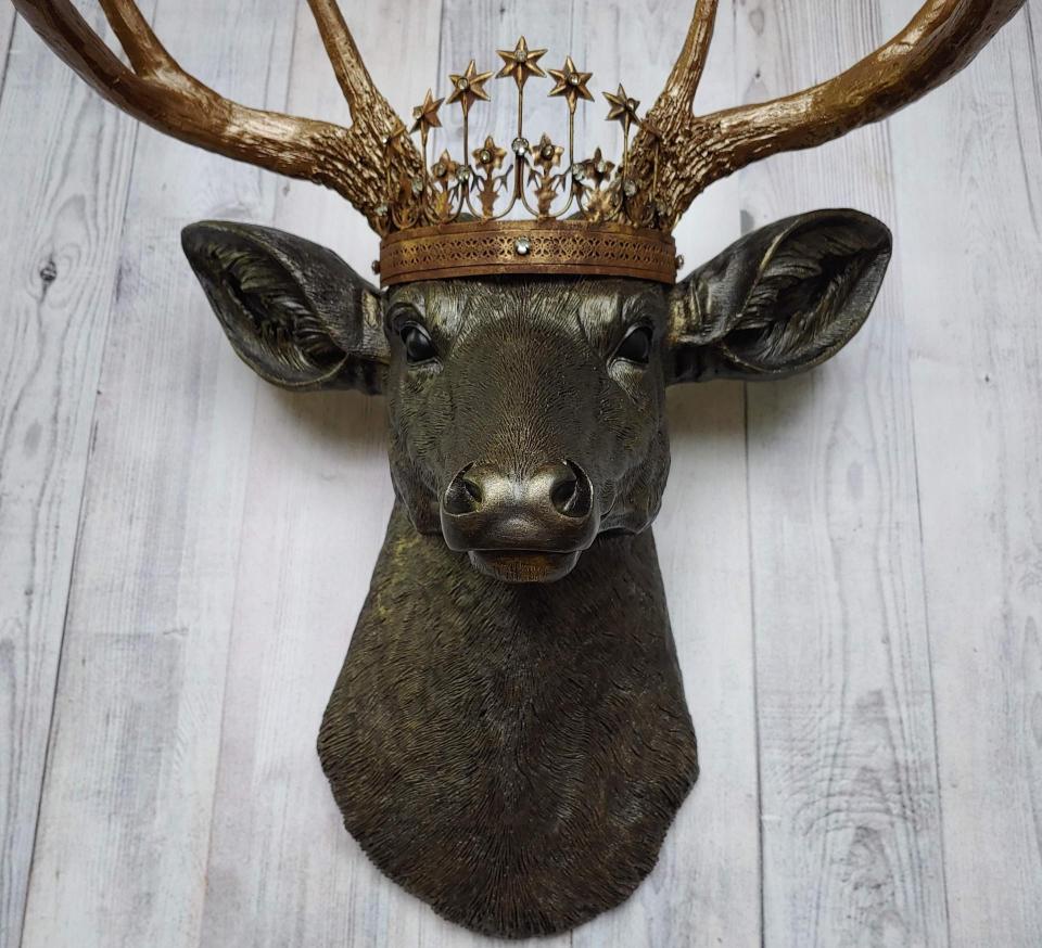 Faux taxidermy stag head, faux taxidermy deer head that's been painted rubbed bronze with antique gold accents. The antlers have been painted antique gold and a vintage inspired Santos crown adorns the deers head.