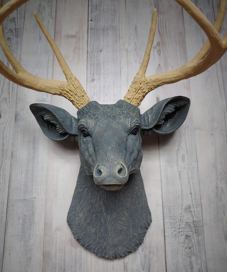 Faux taxidermy deer head that's been painted slate grey with desert sand color accents. The antlers have been painted desert sand.