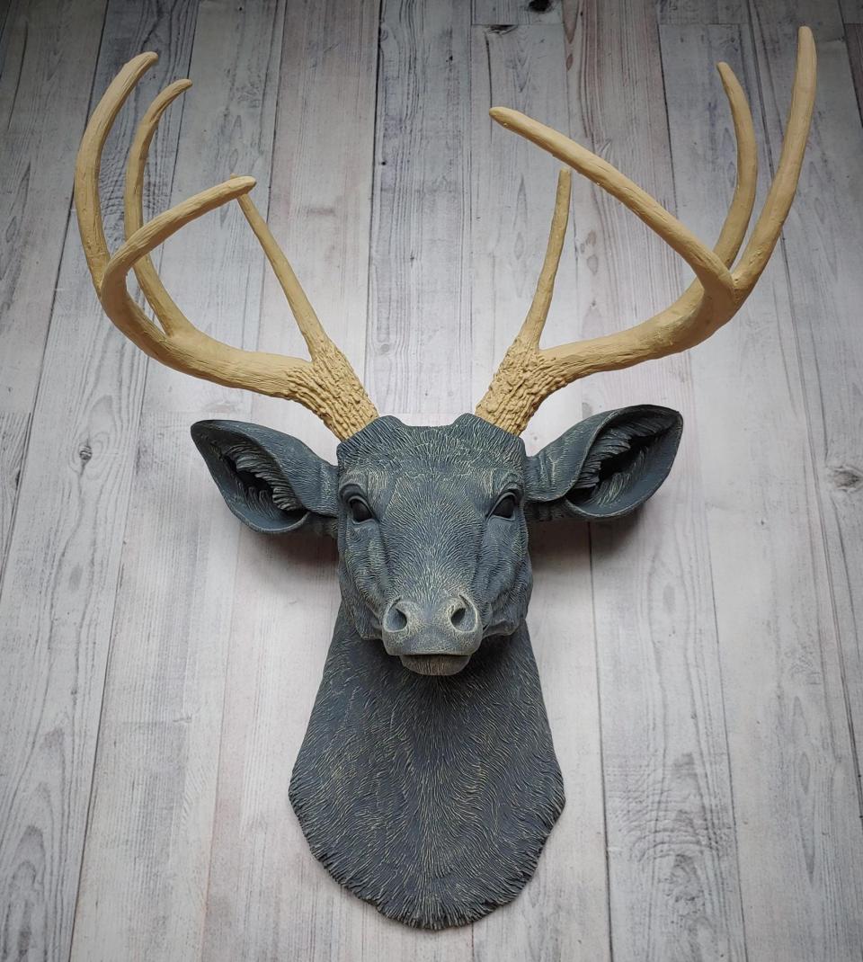 Faux taxidermy deer head that's been painted slate grey with desert sand color accents. The antlers have been painted desert sand.