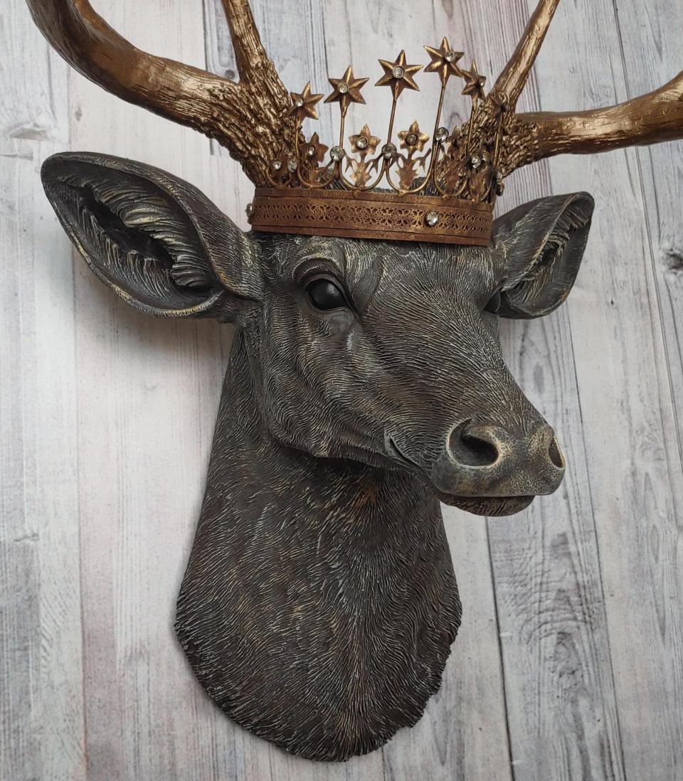 Faux taxidermy deer head, painted chestnut brown with antique white and gold accenting. The antlers are antique gold and a vintage inspired Santos crown sits stop the deers head.
