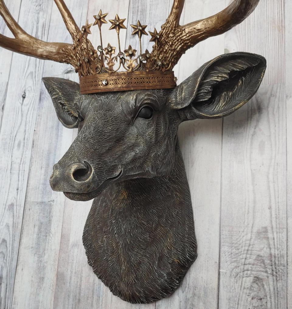 Faux taxidermy deer head, painted chestnut brown with antique white and gold accenting. The antlers are antique gold and a vintage inspired Santos crown sits stop the deers head.
