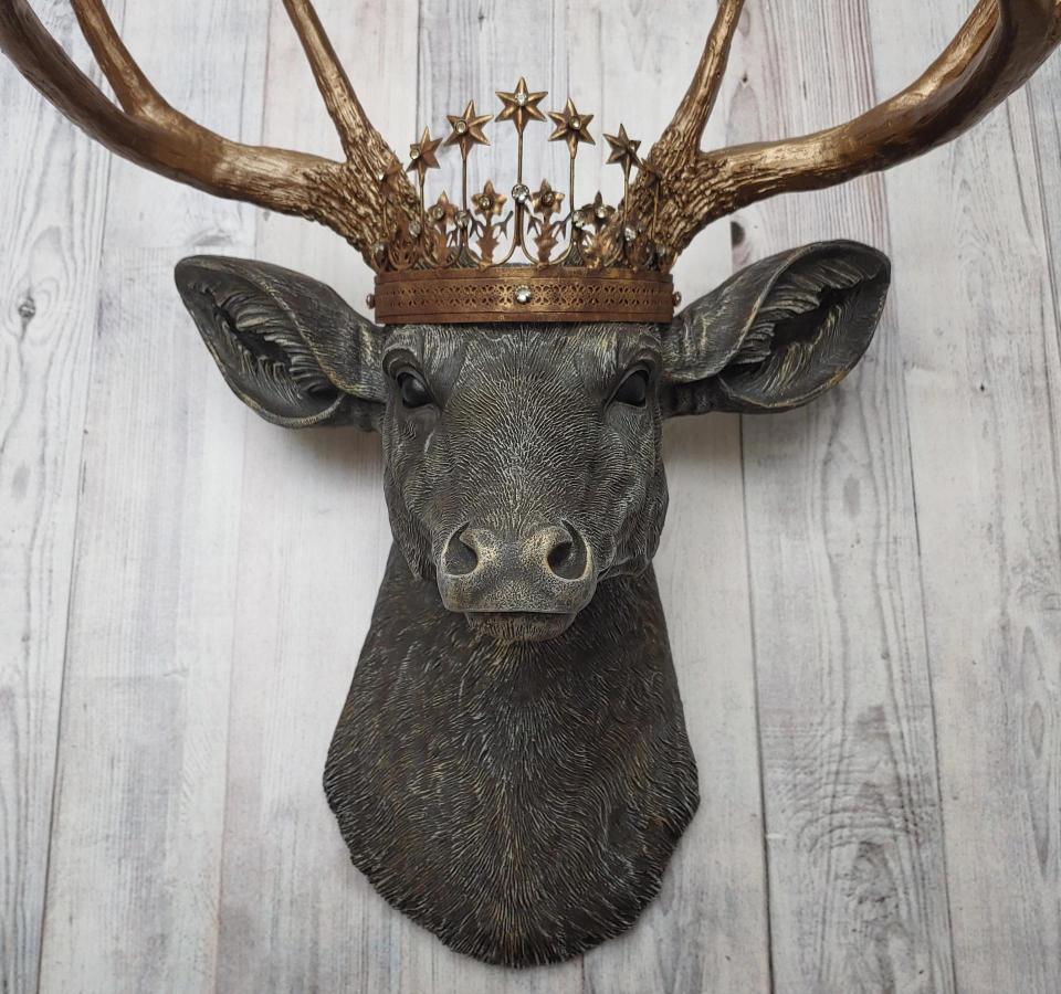 Faux taxidermy deer head, painted chestnut brown with antique white and gold accenting. The antlers are antique gold and a vintage inspired Santos crown sits stop the deers head.