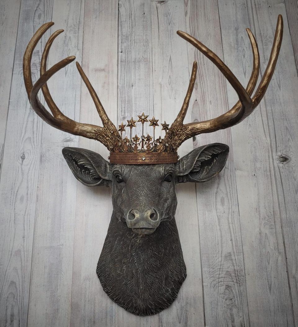 Faux taxidermy deer head, painted chestnut brown with antique white and gold accenting. The antlers are antique gold and a vintage inspired Santos crown sits stop the deers head.