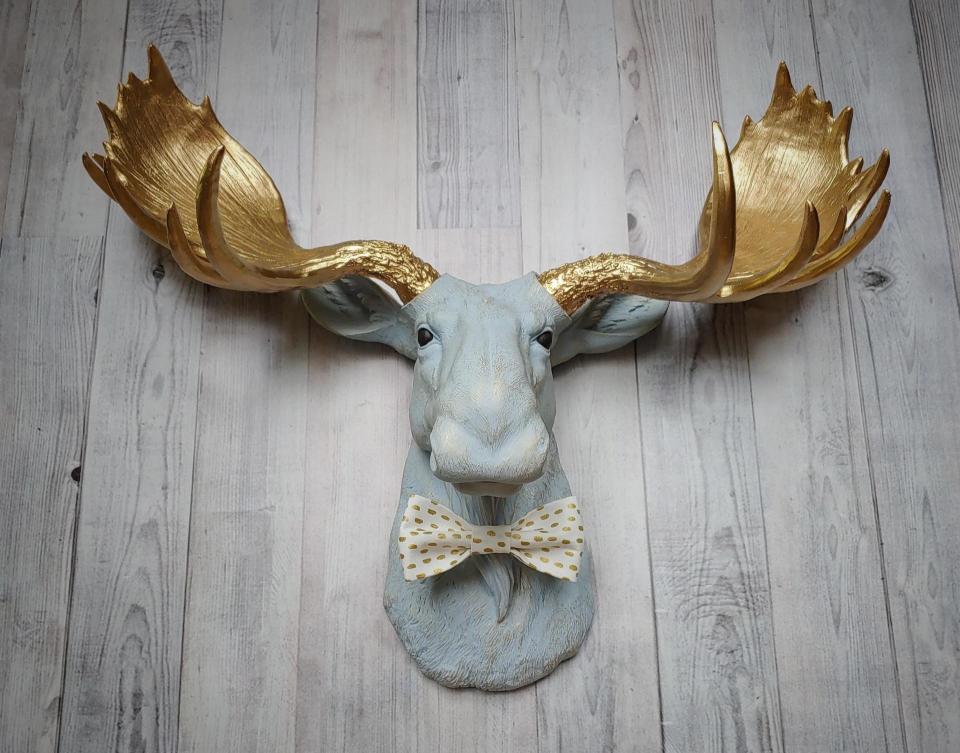 Faux taxidermy moose head painted winter blue with gold antlers with a white and gold polka dot bow tie.