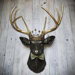 Faux taxidermy deer head wall mount with star Santos crown and a bow tie.